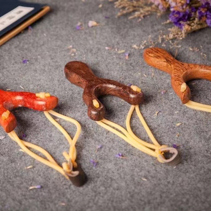 手羽の木の赤い花梨の木のパチンコの木のパチンコの屋外の文はパチンコの平たい皮の筋のパチンコを遊びます。|undefined