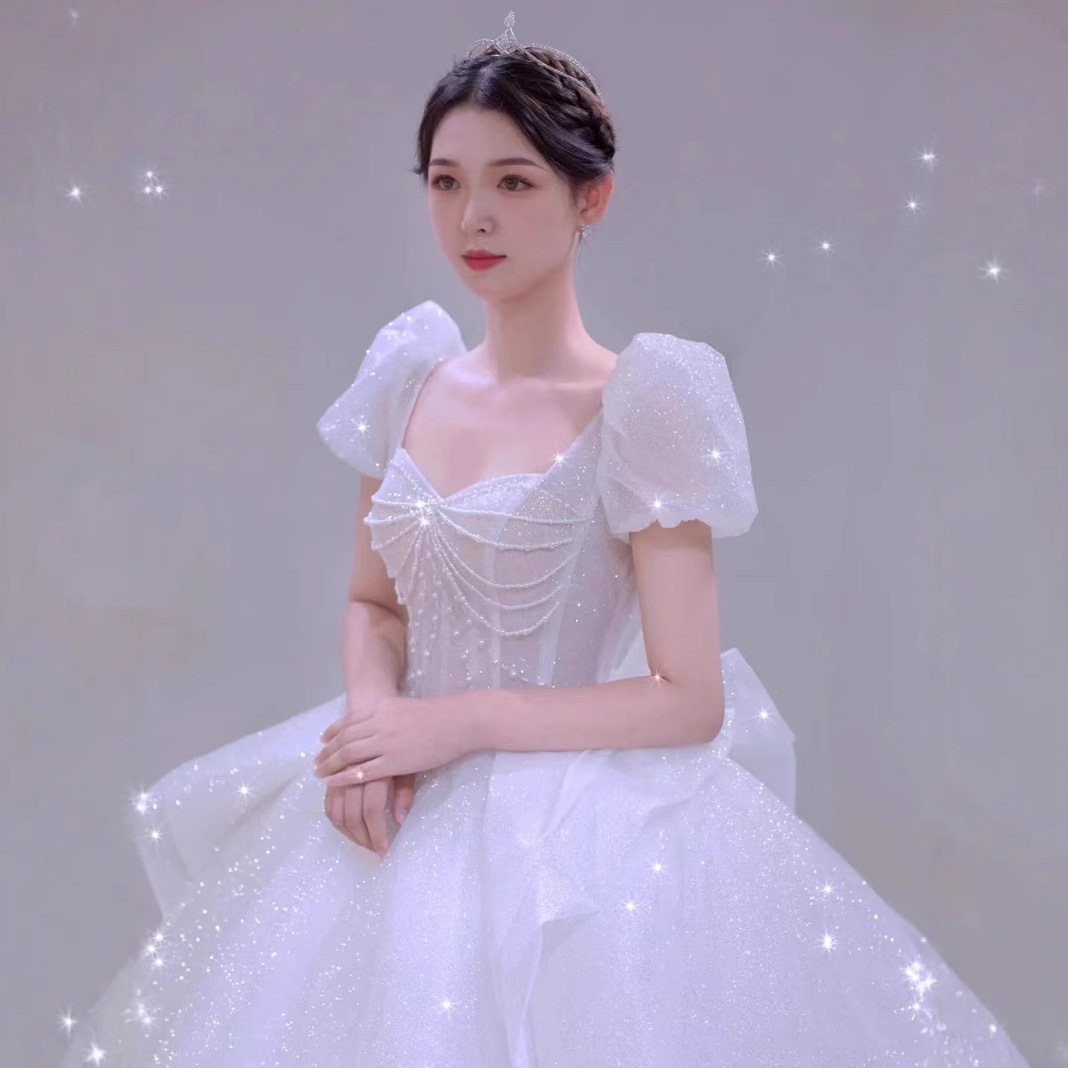 Vestido de novia estilo 2026 con diseño de cielo estrellado, cola estilo francés, mangas abullonadas blancas que cubren los brazos, elegante y grandioso.