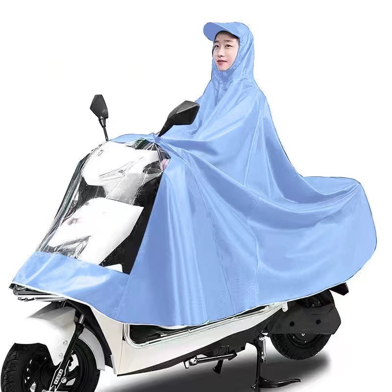 レインコート電気自動車のレインコートを大きくして、オートバイの二人のシングル男性女性が豪雨防止全身に足を隠します。|undefined