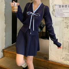 韓系学院風スーツの女性の木の耳元にニットのカーディガンの上着をつなぎ合わせます。