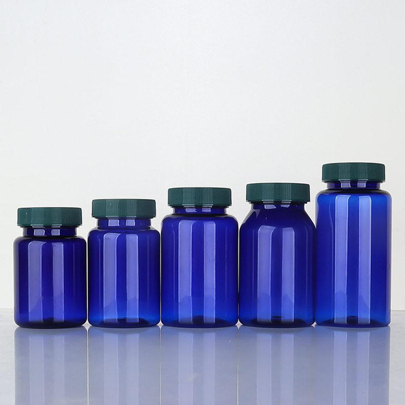 Botella de plástico azul 80–150 ml con tapa estriada, envase para suplementos o cápsulas.