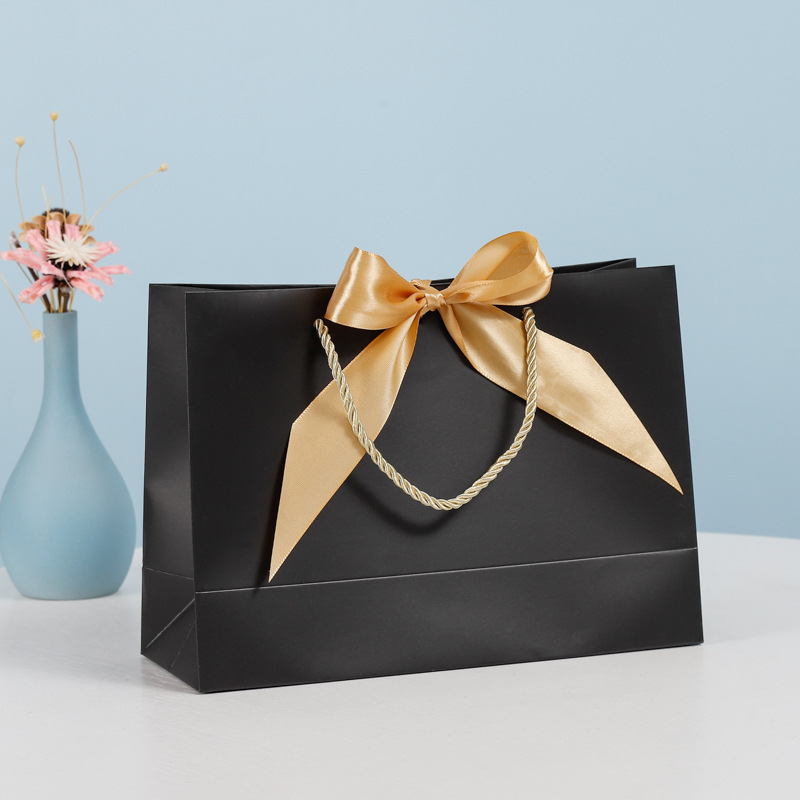 Bolsa de regalo de lazo Bolsa de papel Bolsa de embalaje de ropa Bolsa de cosméticos al por mayor Bolsa de compras Bolsa de mano con logotipo impreso