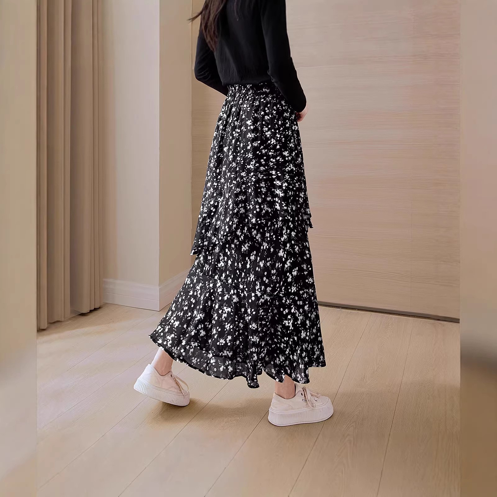 Chân váy xòe họa tiết hoa nhí, xếp ly nhẹ, thiết kế xẻ tà thanh lịch — màu đen