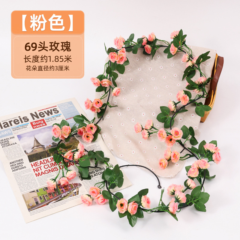 Simulación de flores falsas rosas de caña colgando la pared tubería de drenaje envuelta hoja verde que cubre la parte superior de la decoración de boda de plástico