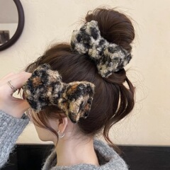 ぬいぐるみのヒョウ柄の蝶結びの団子の頭は女性の秋冬の気質をつかんでサメのクリップの高級感の馬尾のヘアピンを出します。