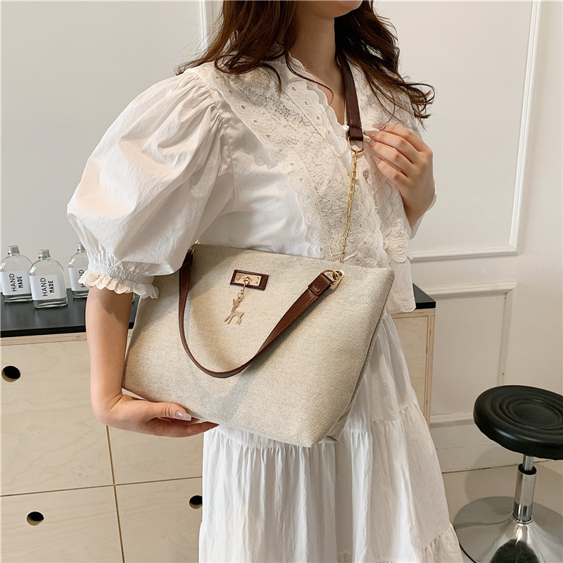 Textura simple, bolso de hombro versátil 2024 nueva moda moda de gran capacidad, bolso de transporte ligero, bolso de brazo