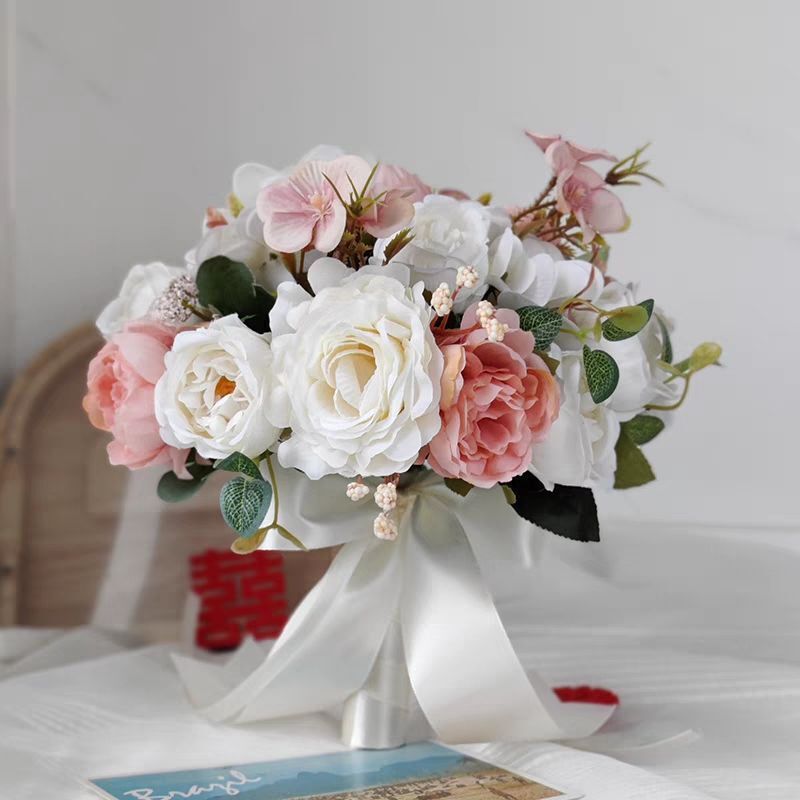 手に花を持つ新婦の韓国式結婚式の領収書のシミュレーションの花束の森系のウェディングドレスの撮影の道具の手に花をささげます。|undefined
