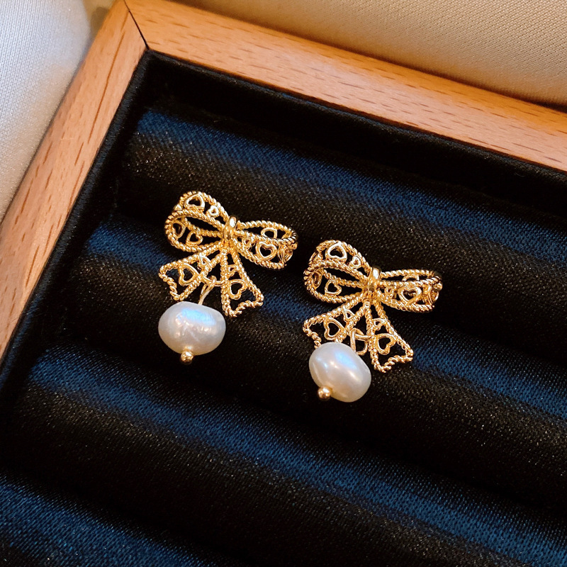 Pendientes de perlas artificiales de mariposa de aguja de plata Pendientes de todo fósforo de nicho retro femenino Pendientes de temperamento de moda Lujo ligero de alta gama