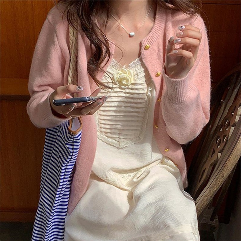 レトロで優しい風の小金はニットの女性のカーディガンを掛けます。|undefined