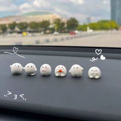 かわいいアニメの丸々とした置物の自動車のバックミラーのディスプレイの中でコンソールの車内のスクリーンの装飾品のネットの赤い車に乗ります。