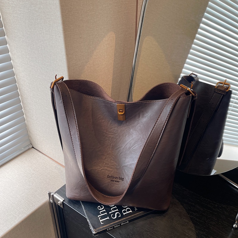 Bolsa de viaje retro coreana para mujeres 2025 invierno nuevo paquete de cubo de hombro de gran capacidad bolsa de mochila casual