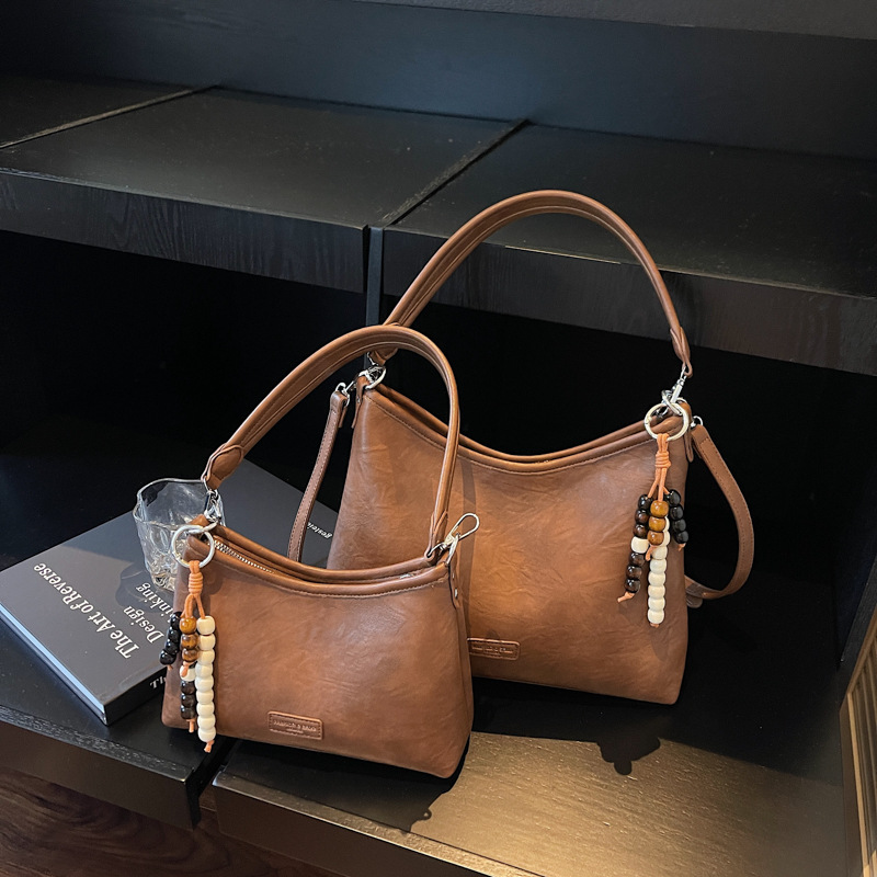 Bolsa de hombro con brazalete coreana de alto valor en otoño y invierno 2025 nuevo estilo retro simple bolso de mochila casual bolso de mano
