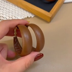 美ラードカレー色の皮質は大耳輪のイヤリングを誇張しています。