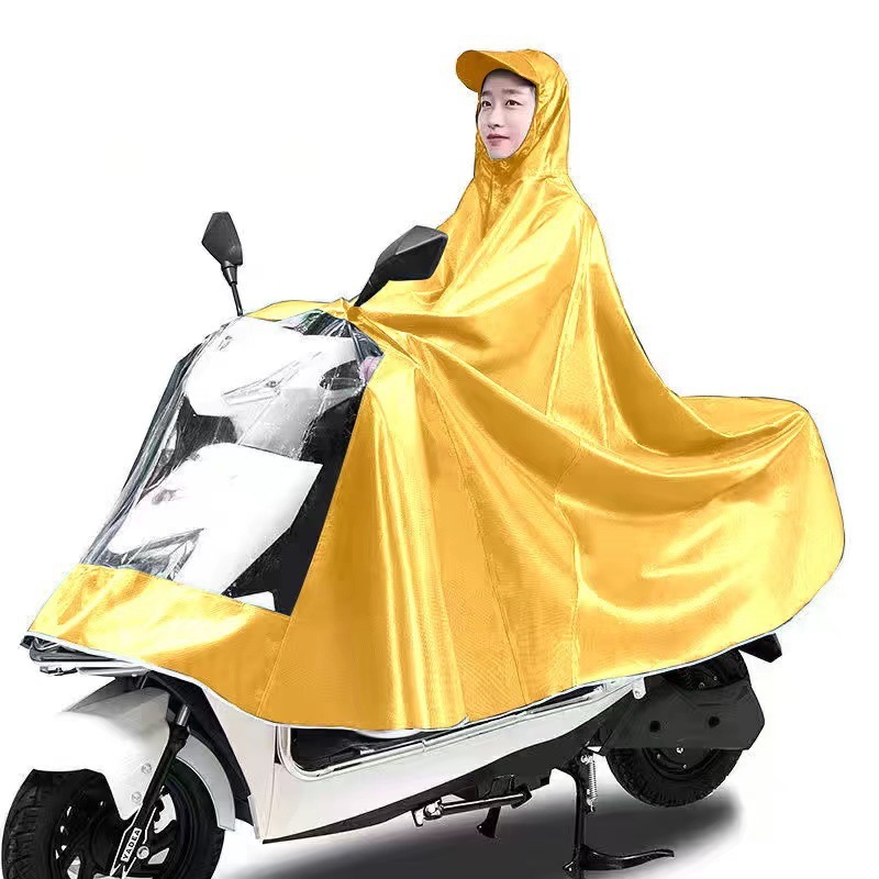レインコート電気自動車のレインコートを大きくして、オートバイの二人のシングル男性女性が豪雨防止全身に足を隠します。|undefined