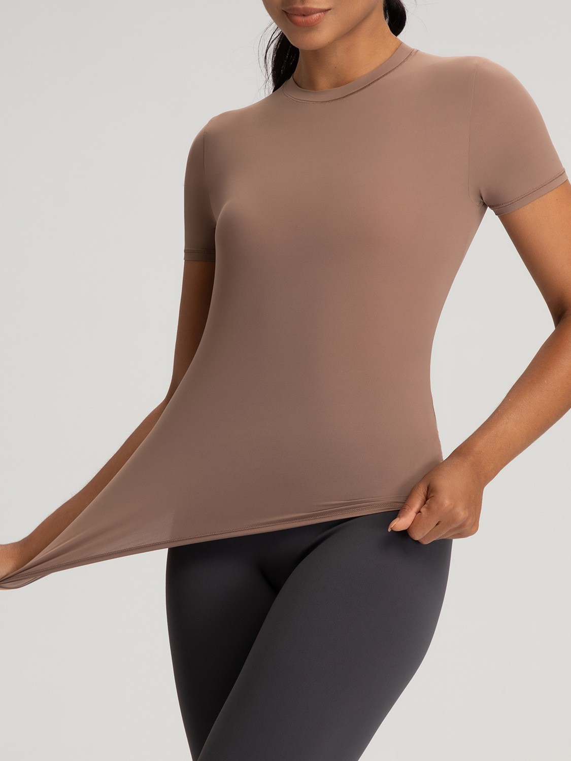 欧米の新型ヨガ服の女性のカーダシアンは同じタイプのスリムな半袖の上着の高弾の薄い運動のフィットネス服を見せます。