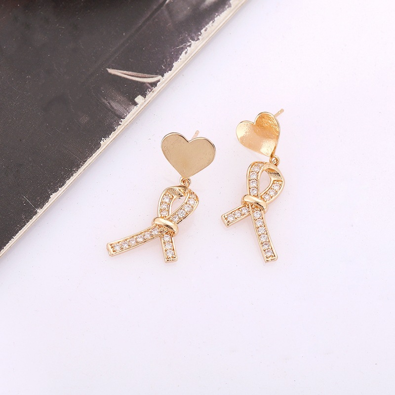 Estilo coreano nuevo melocotón corazón Stud pendientes de las mujeres de alta calidad de La pajarita Cruz diseño pendientes ins Internet Celebrity todo fósforo de la joyería de moda