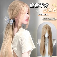 金色のかつらの女性の中で八の字の長さのまっすぐな髪を分けます。