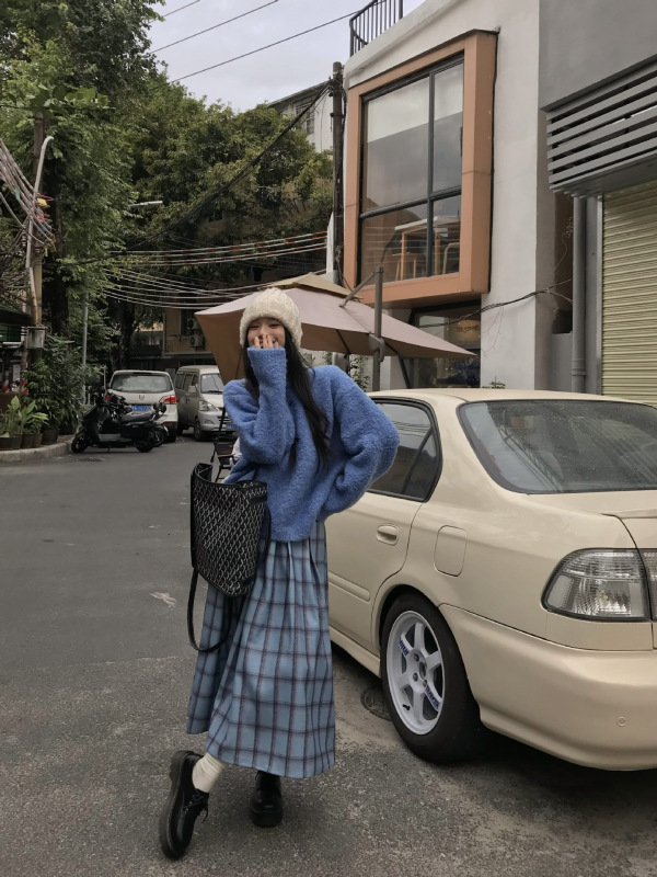 韓国系は青いニットのセーターを着ています。|undefined