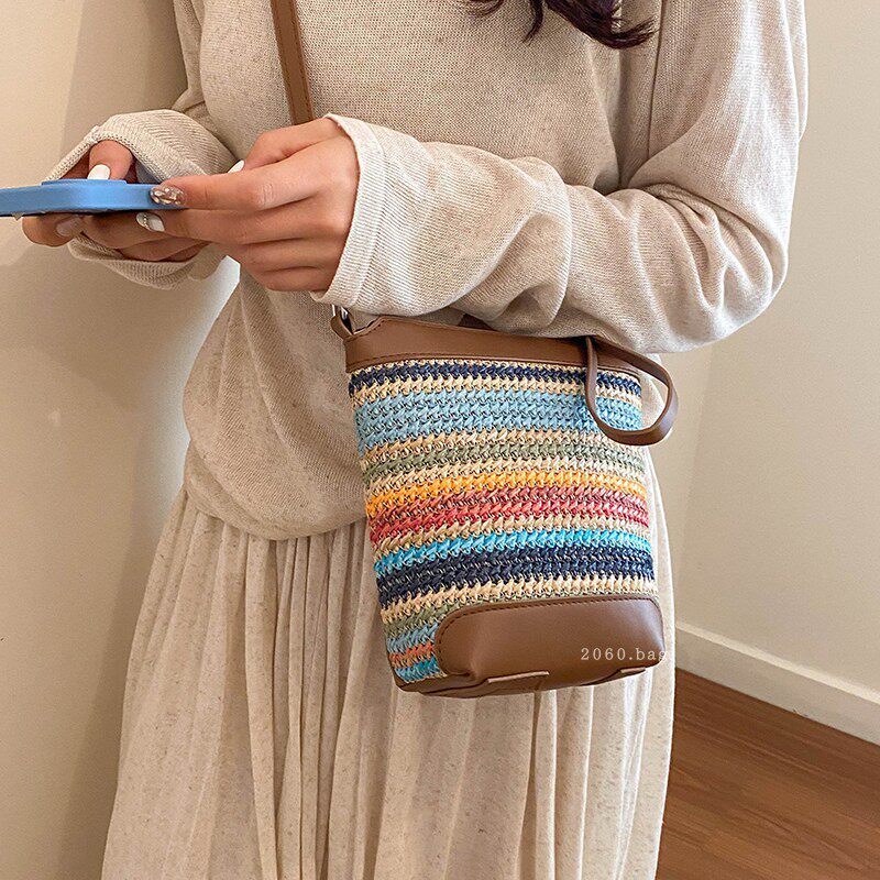 Vacaciones de un solo hombro cubo nuevo bolso de estilo 2026 nicho de moda de playa de arena inclinada mujer tejido bolso a rayas de verano