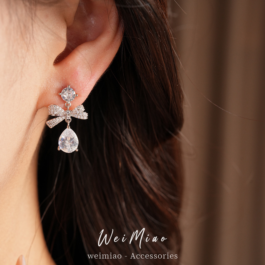Aguja de plata zircon arco gotas de agua simple temperamento moda aretes de aretes ligeros de lujo alta sensación de aretes al por mayor