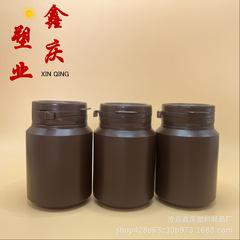 現物はふたをひっくり返してふたを引き裂いてプラスチックの瓶の広口のプラスチックの瓶のコーヒー色のタブレットのキャンディーの瓶を引き裂きます。
