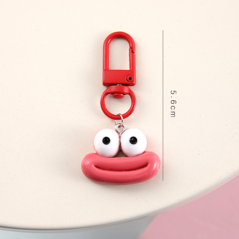 かわいいアニメの大きな口のキーホルダーは学生のカバンを飾っています。