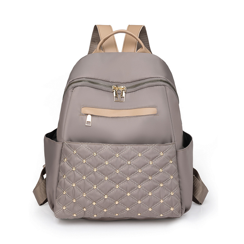 2023 nueva mochila de nailon para mujer coreana, remache de diamantes de moda, mochila de viaje de cercanías de gran capacidad al por mayor