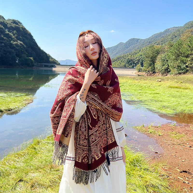 民族風のマフラーの女性は冬に保温エアコンの部屋のストールを厚くします。|undefined