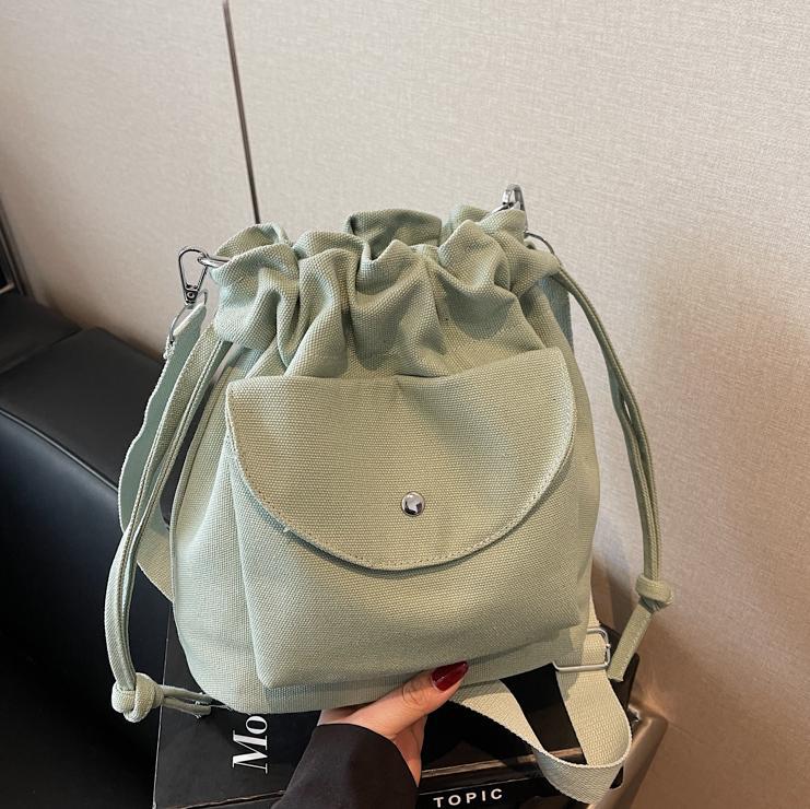 Bolsa de cubo de lona de moda de comercio exterior para mujeres 2025 nuevo estilo versátil bolso de hombro simple ocio nicho plegado mochila