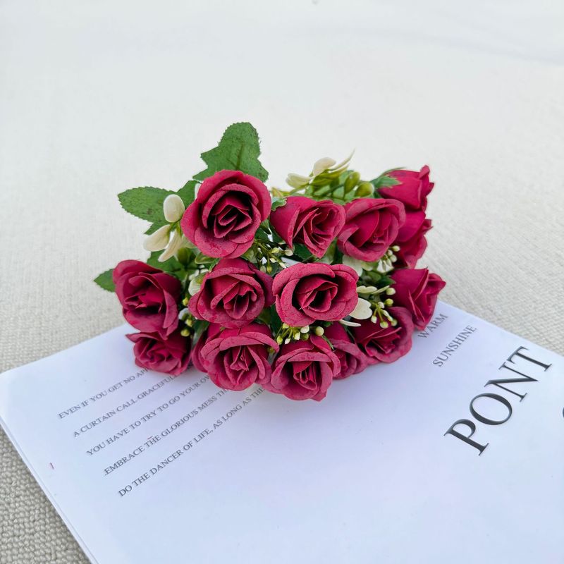 模造花ミニバラは花を手にして家にいる結婚式の室内客間の装飾に造花を飾っている|undefined