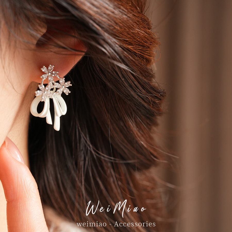 Aguja de plata goteando aceite de zircon flores arco pernos temperamento moda aretes dulces ligero lujo alta sensación de auriculares al por mayor