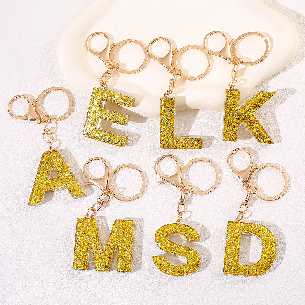 Cute golden keychain for keys with tassels with letters