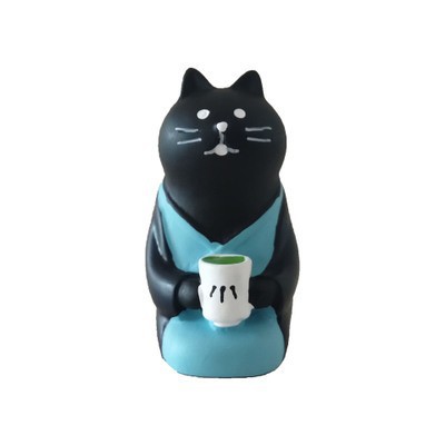 무릎을 꿇고 차를 마시는 검은 고양이