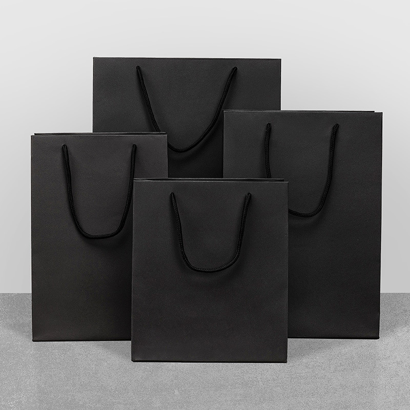 Bolsa de regalo de papel Kraft bolsa de embalaje de cartón negro en stock bolso de regalo de ropa ventas directas de fábrica