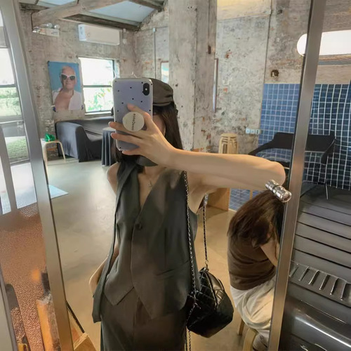 A vintage-style suit set with a sleeveless gray waistcoat for women, featuring a half-body skirt with slits for summer, exuding a sense of elegance - a two-piece set.