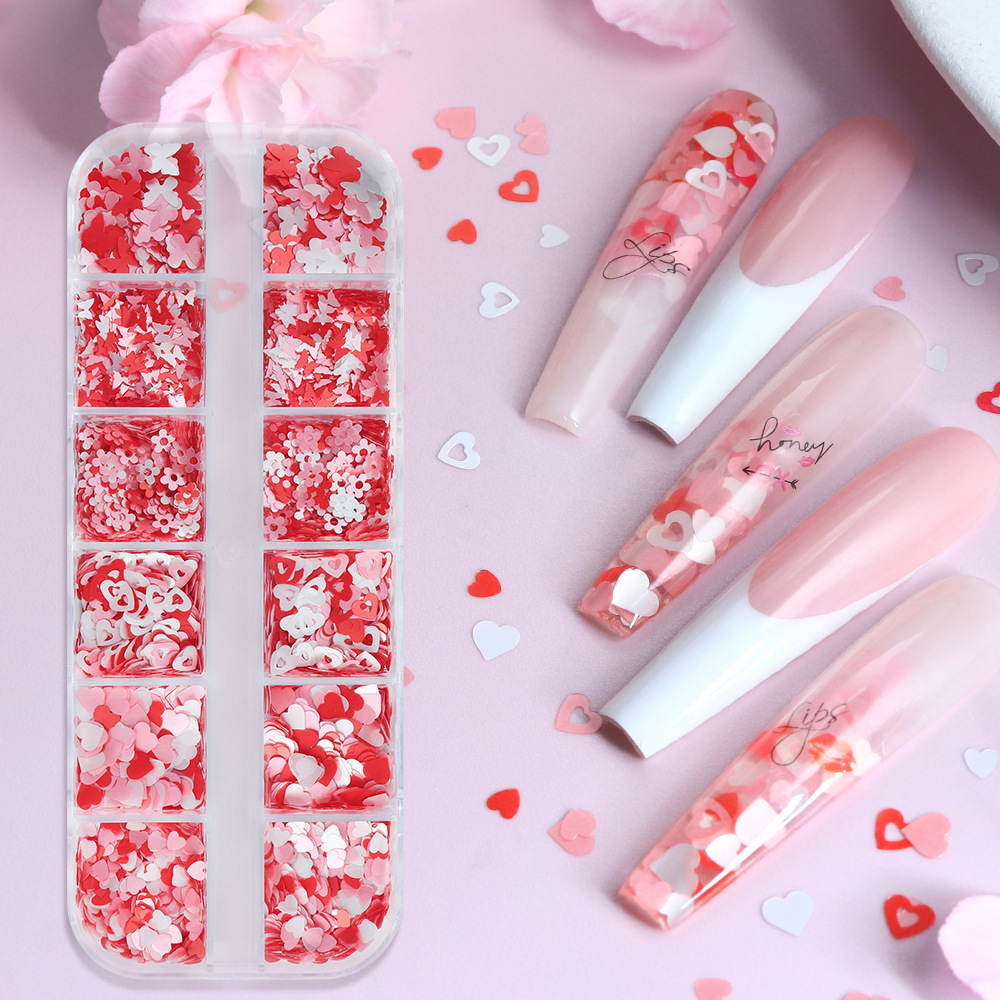 Caja de 12 compartimentos con accesorios perlados para decoración de uñas en forma de corazón, lentejuelas para uñas con diseño de mariposas y flores en rosa y blanco para el Día de San Valentín, decoraciones coloridas.