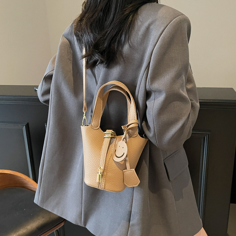 Bolso de cubo portátil con patrón de lichi de alta gama para mujer 2025 nuevo bolso de hombro de todo fósforo de moda bolso de mensajero casual de estilo occidental