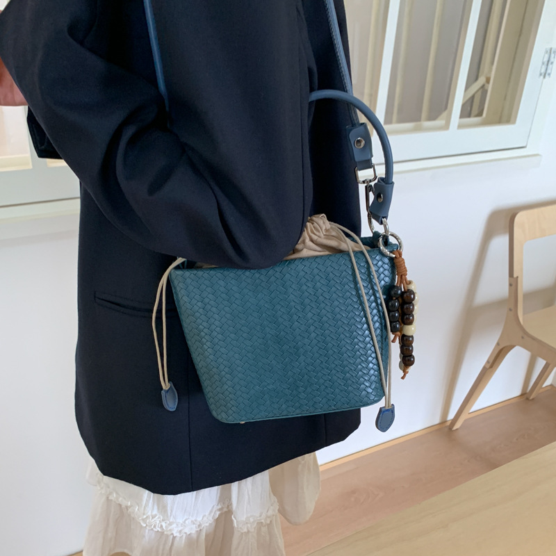 Transfronterizos bolsos de cubo de cuerda bolsos de mujer versátiles bolsos de mano otoño e invierno 2025 nuevo tejido mochila de viaje