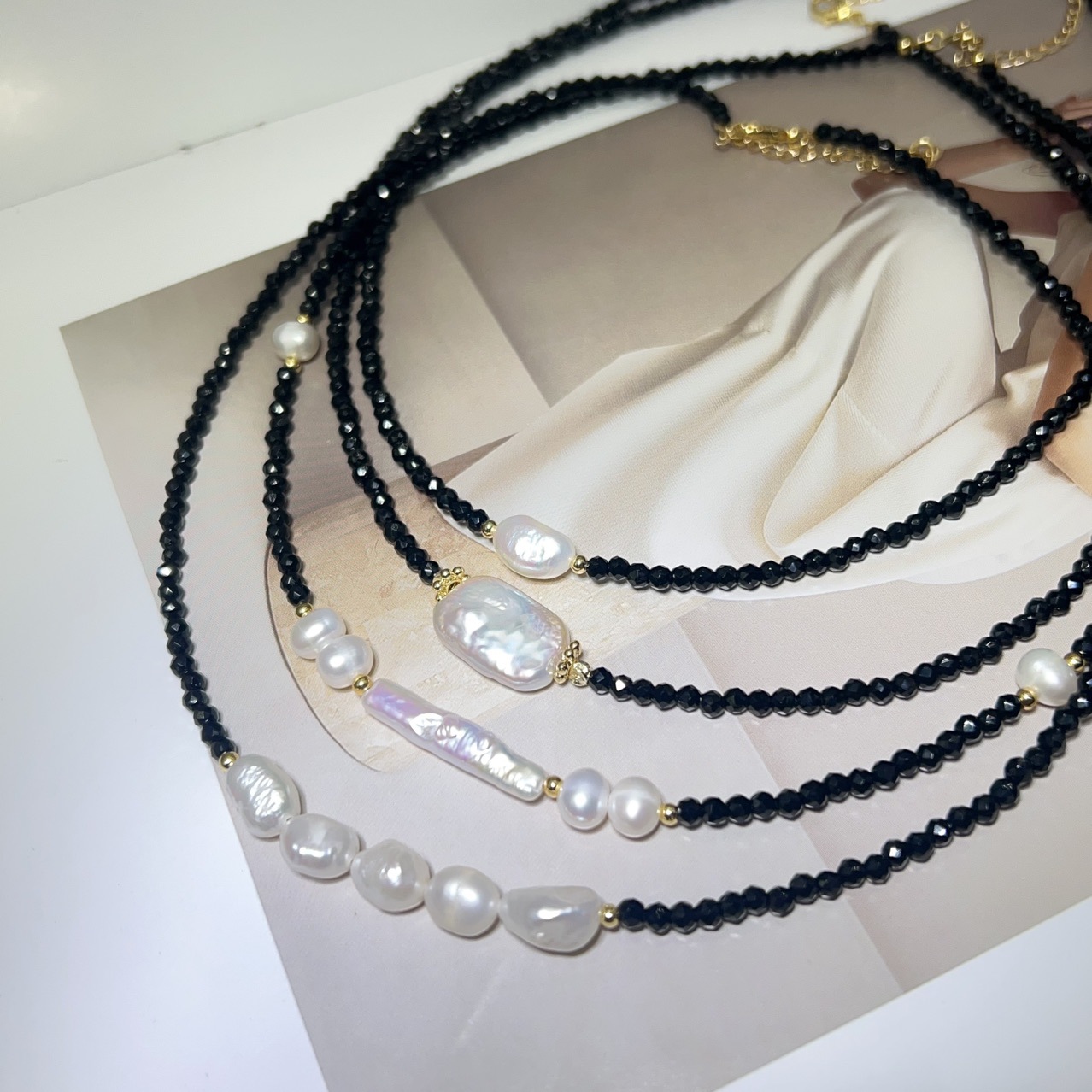 A uniquely shaped baroque pearl clavicle necklace with vintage black spinel and small silver bars, exuding French elegance with freshwater pearls.