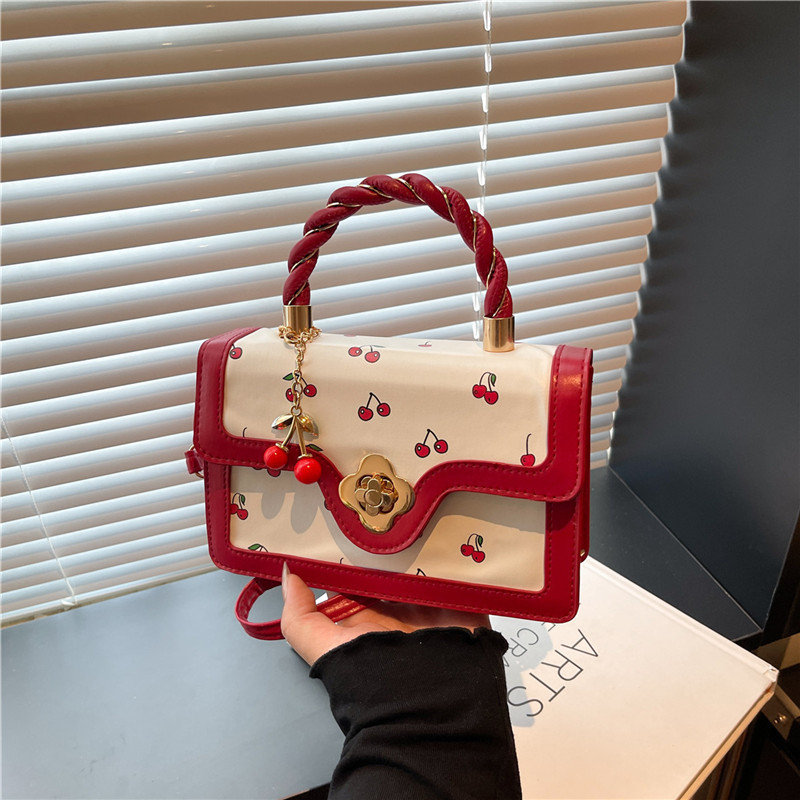 2025 nuevo bolso de mensajero con estampado de cereza lindo bolso cuadrado pequeño portátil girando bolso de niña de diseño de color de contraste fresco