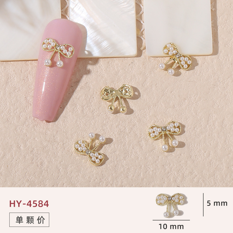 Uñas mariposa joyería nueva línea popular perla arco metal decoración de uñas pequeños accesorios de joyería al por mayor