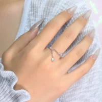 Минималистичное и сдержанный стильное кольцо на указательном пальце с кисточкой, маленькими круглыми бусинами и цепочкой.