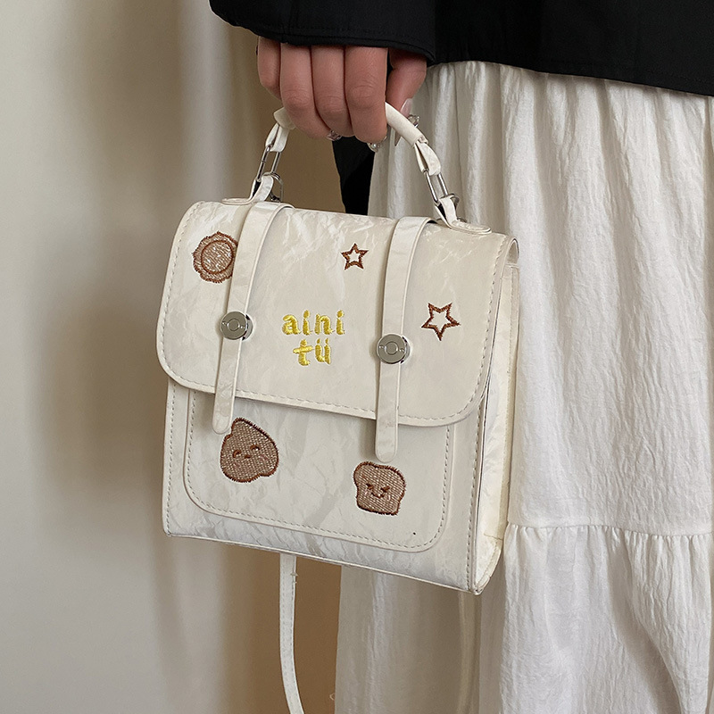 Bolsa universitaria viento rojo para mujeres 2025 nueva moda alta sensación de mochila de viaje universal mochila