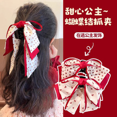 逃げている王女の甘い女の子の王女の頭の赤い蝶結びの髪はネットの赤い波を挟んで子供の髪をつかみます。