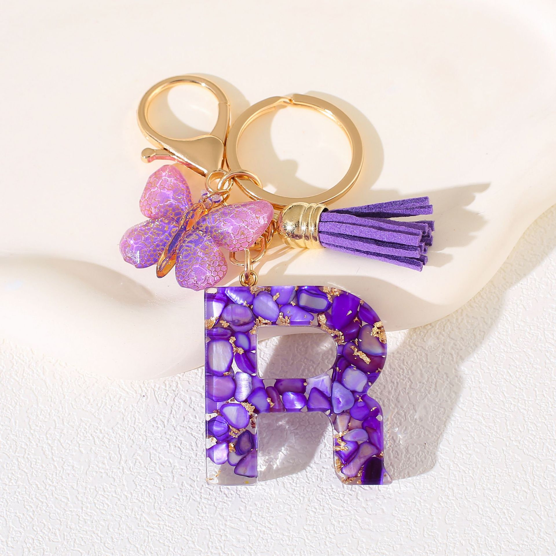 Fábrica directa de Yiwu accesorios de resina de goteo de embalaje llavero anillo de metal letras mariposa brilla colgante damas