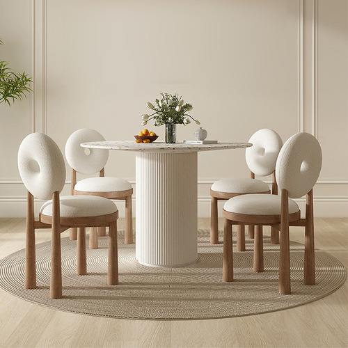 Trendy Instagram-worthy cream-colored lambswool chair set with Wabi-Sabi-style polished stone round dining table and chairs, perfect for compact spaces—featuring a sleek rock slab top paired with solid wood dining table.
