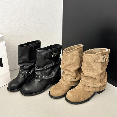 Vintage black short boots for women with new riveted trouser legs, Western boots, pleated, stacked, and motorbike boots on the trendy street.
