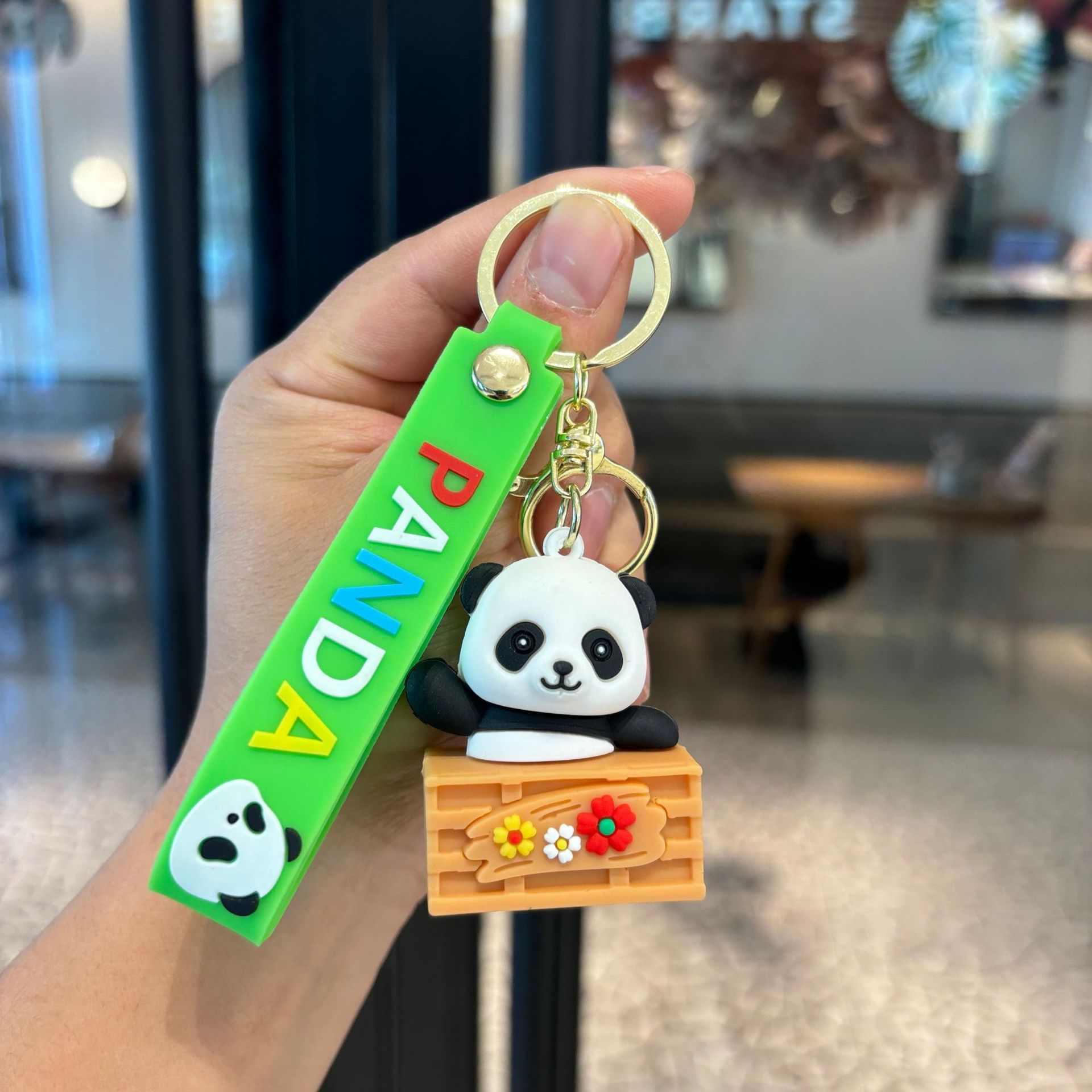 アニメは竹のパンダのキーホルダーを抱いてかわいいパンダのカップルの小銭入れを掛けます。