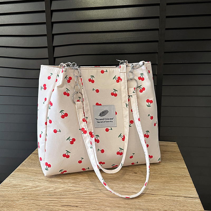 Moda pequeña y fresca impresión de cereza bolsos de invierno 2025, bolsos de mujer nuevos, bolsos de gran capacidad, bolsos de mujer de estilo exterior.