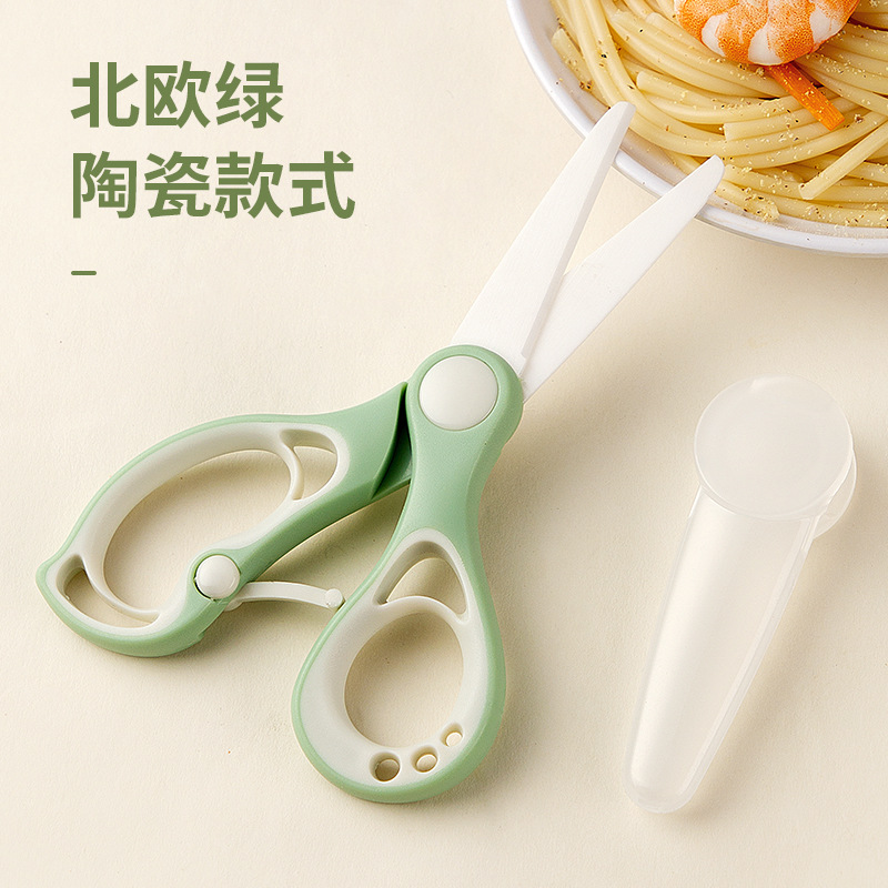 陶磁器のサプリメントは赤ちゃんの食べ物を切ります。はさみは携帯で肉を切ります。